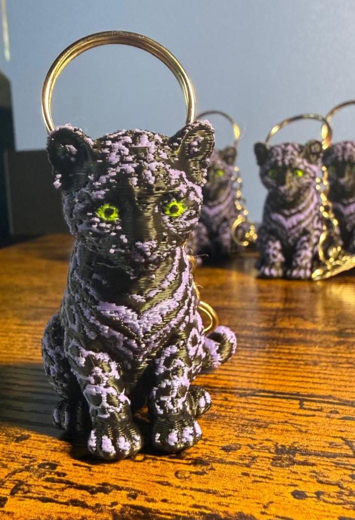 Leopard, schwarz-lila mit PLA gedruckt, mit gelben, leuchtenden Augen (fluoriscent Acryl), Metallring und kleiner Karabiner